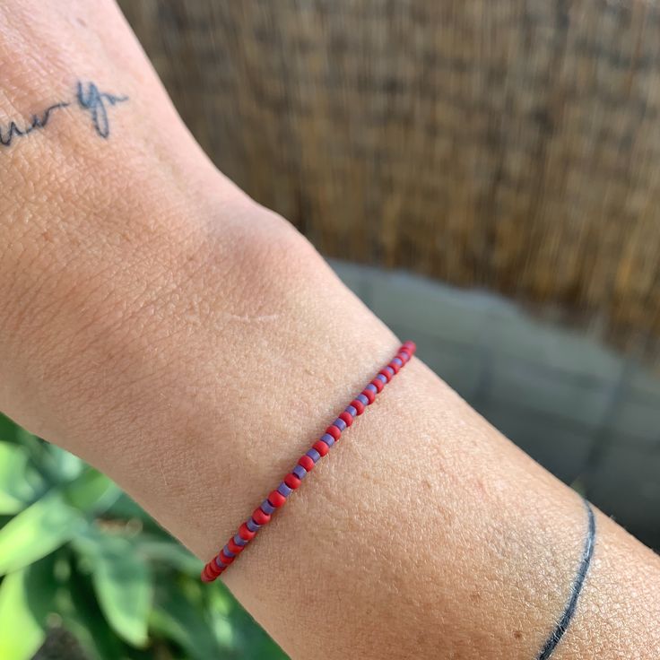 red and purple seed bead bracelet Red Adjustable Friendship Bracelets With Tiny Beads, Adjustable Red Friendship Bracelets With Tiny Beads, Hand-strung Red Braided Friendship Bracelets, Red Hand-strung Braided Friendship Bracelets, Adjustable Red Friendship Bracelets With Colorful Beads, Beach Red Friendship Bracelets With Colorful Beads, Red Braided Friendship Bracelets, Red Letter Beads For Friendship, Beach-friendly Red Colorful Beads Friendship Bracelets