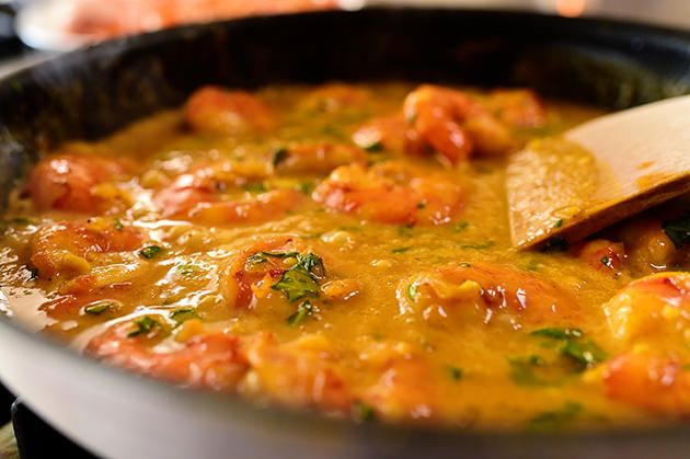 a skillet with some food in it and a wooden spoon inside the pan on the stove