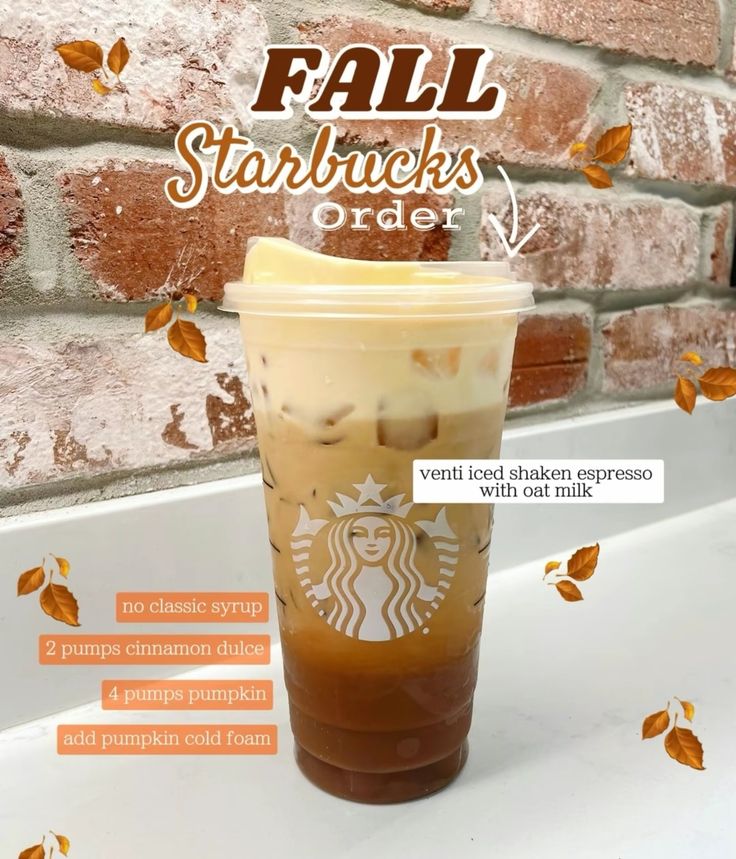 starbucks fall starbucks frapper is on display in front of a brick wall with autumn leaves around it