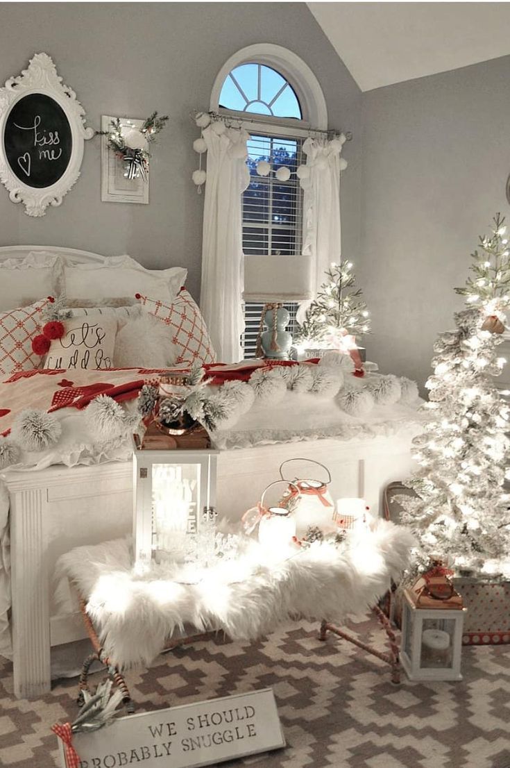 a bedroom decorated for christmas with white furniture and decorations