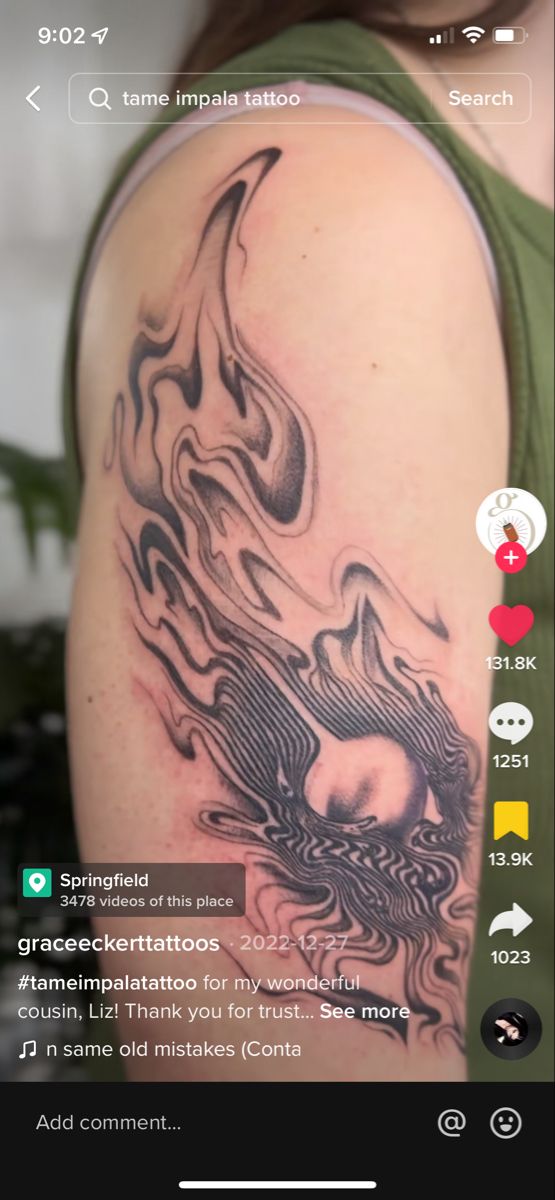 a woman's arm with tattoos on it and an image of a dragon in the background