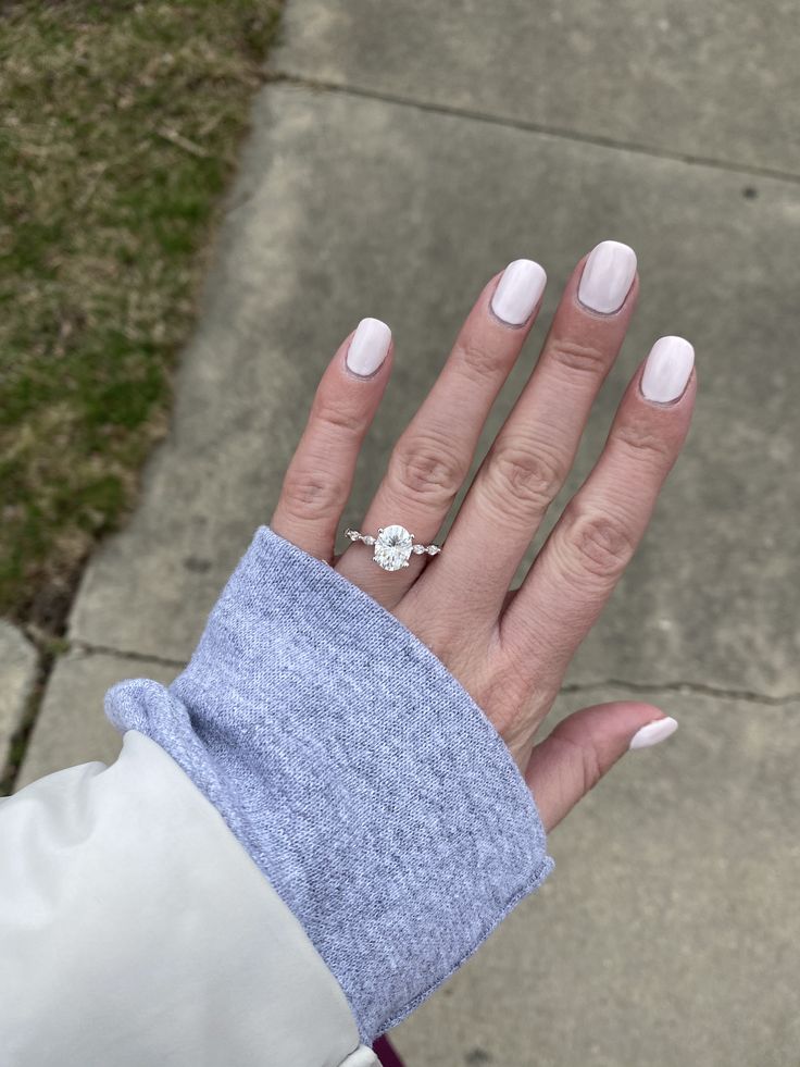 a woman's hand with white manicures and a ring on her finger