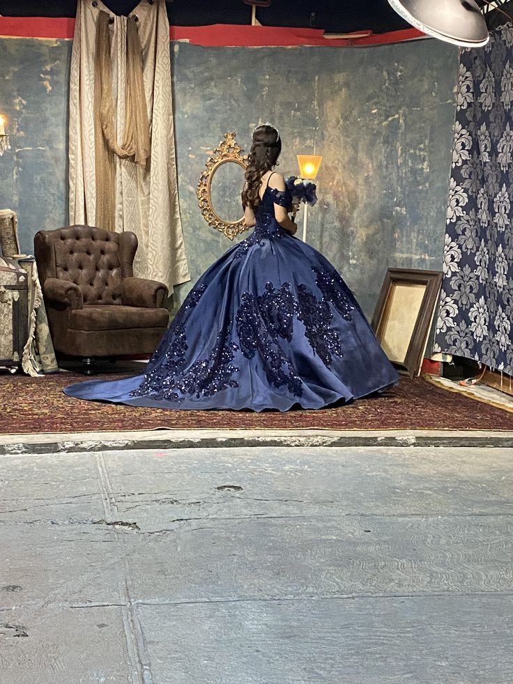 a woman in a blue dress is sitting on the floor