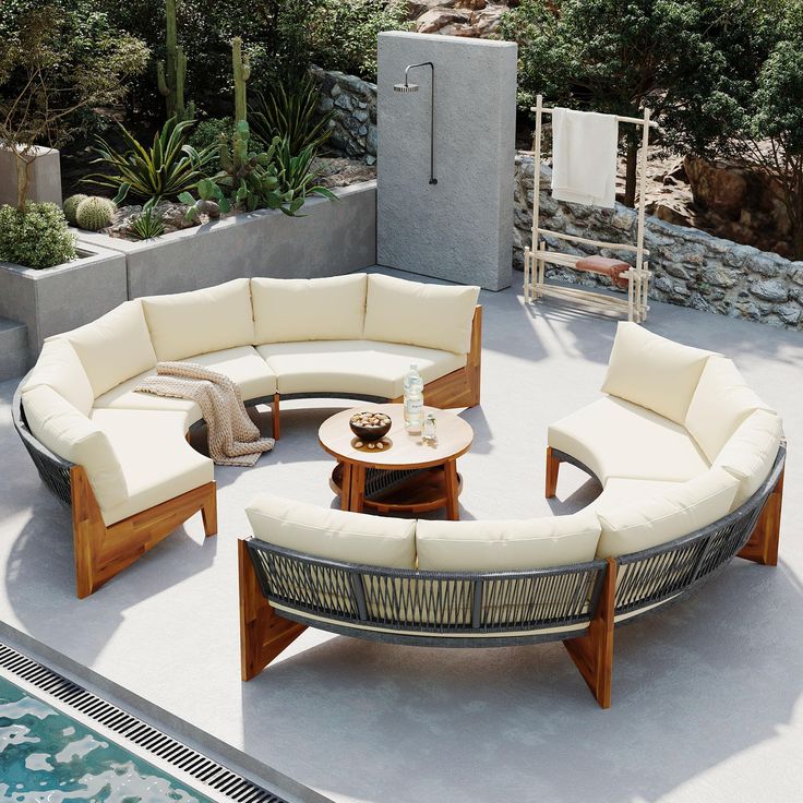 an outdoor living area with couches and tables next to a swimming pool in the background