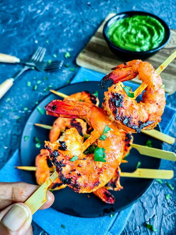 grilled shrimp on skewers with green dipping sauce