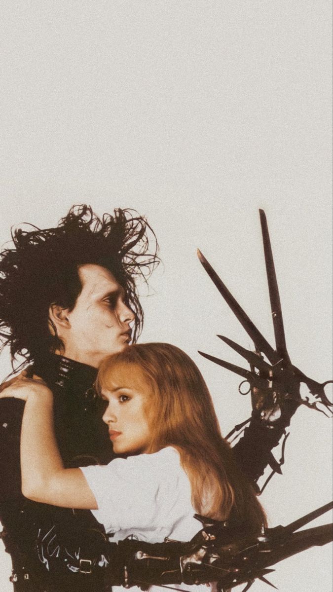 a man holding a woman in his arms with scissors all around him and her hair flying through the air