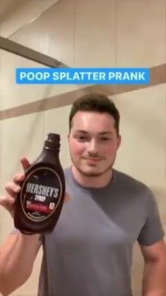 a man holding up a bottle of hershey's pop splatter prank