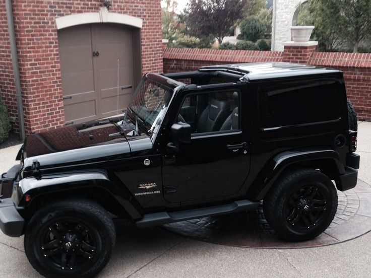 a black jeep parked in front of a brick building