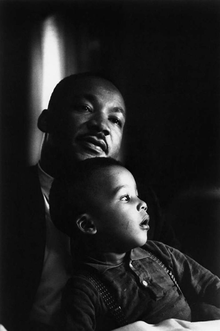 a black and white photo of two men with one holding the other's head