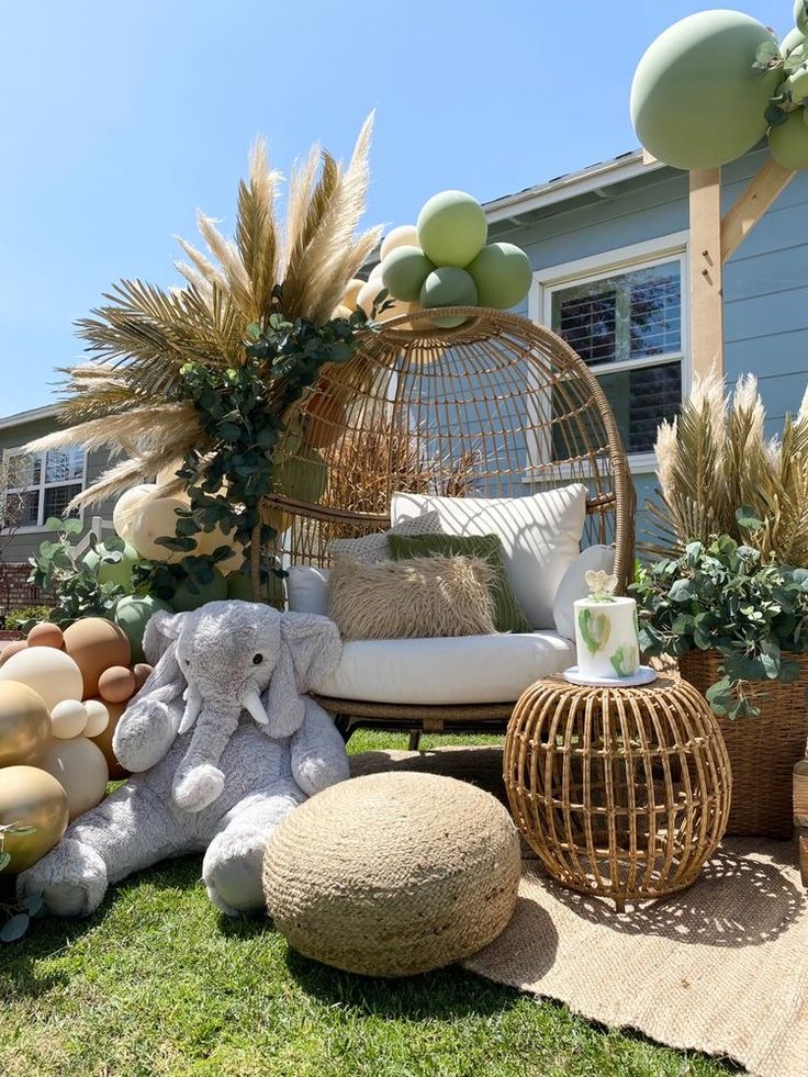 an outdoor area with plants and stuffed animals on the grass, including a birdcage