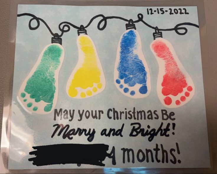 a christmas card with three handprinted feet hanging from a string and the words, may your christmas be merry and bright 4 months