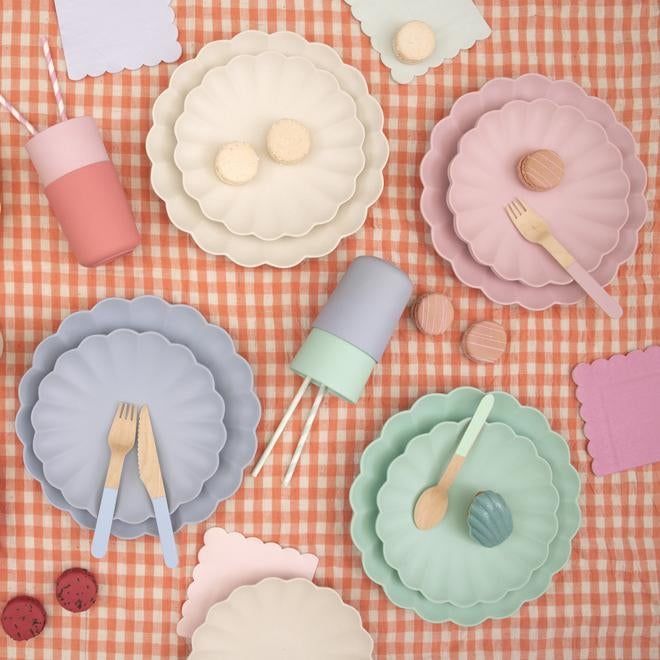 there are many plates and utensils on the checkered table cloth with spoons