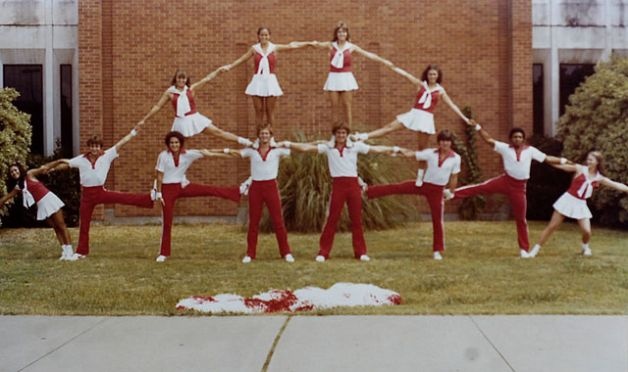 a group of young women standing in front of a building with their arms stretched out