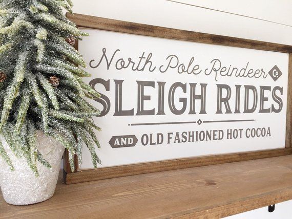 a wooden sign that says north pole reindeer sleigh rides and old fashioned hot cocoa