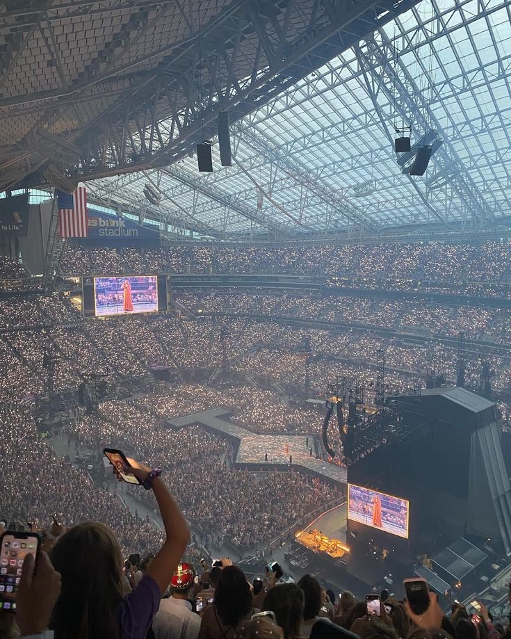 a large crowd at a concert with cell phones in their hands and on to the stands