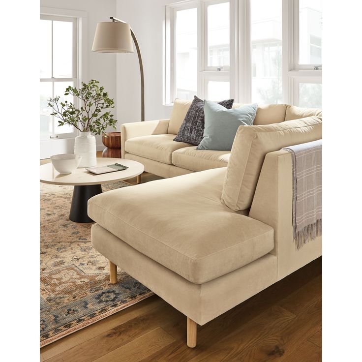 a living room filled with furniture and a large rug on top of a hard wood floor