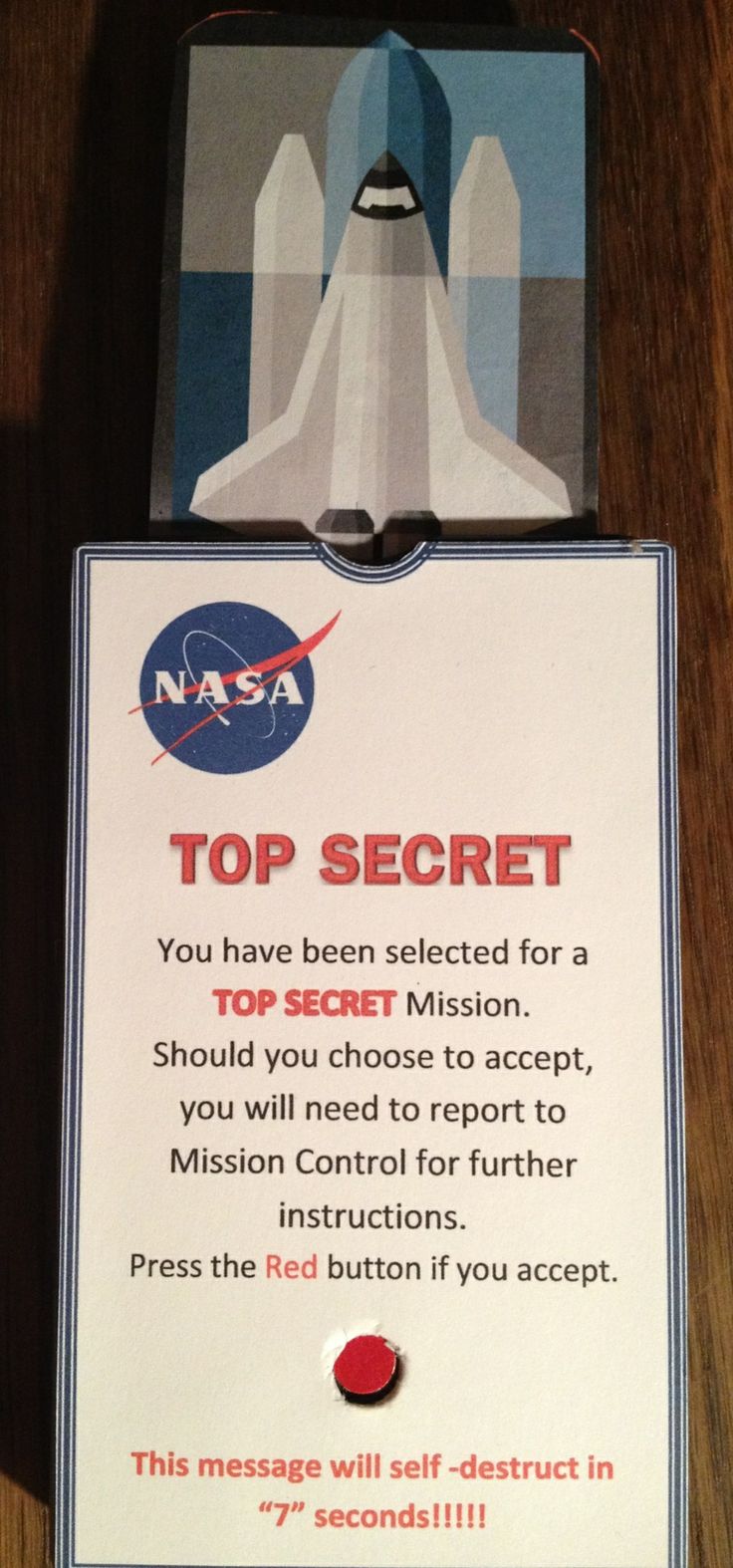 a sign that is on top of a wooden table in front of a nasa card