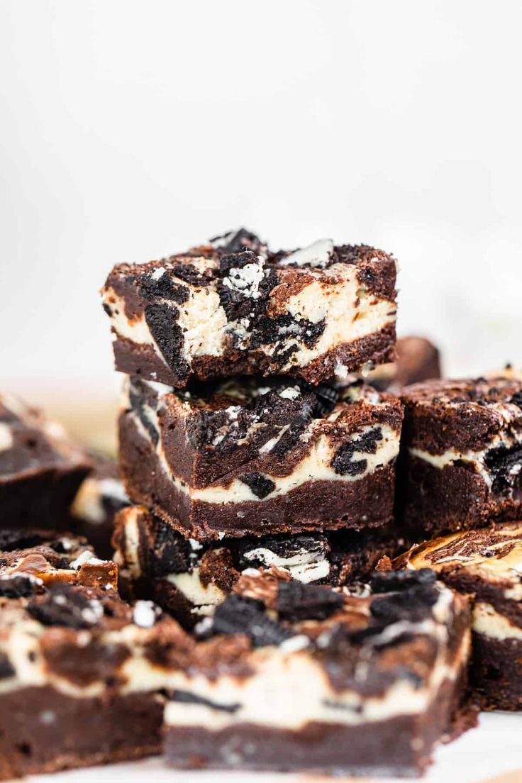 a pile of brownies with oreo cookies and cream on top, stacked together