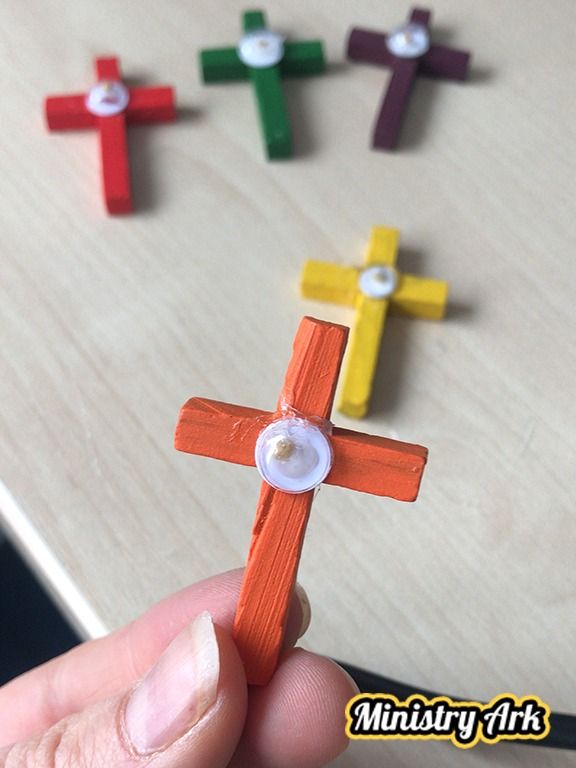 a person holding a toy cross in their hand