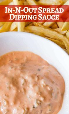 a white bowl filled with dipping sauce next to french fries and ketchup on the side