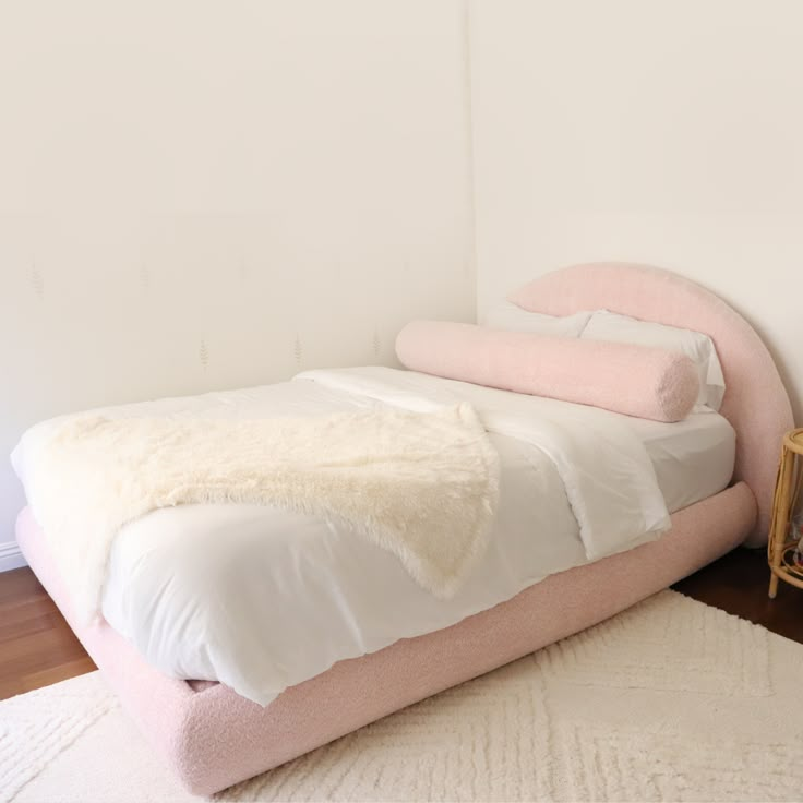 a bed that is made up with blankets and pillows on top of it in a room