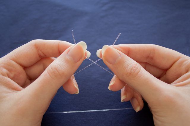 two hands are holding pins in front of each other