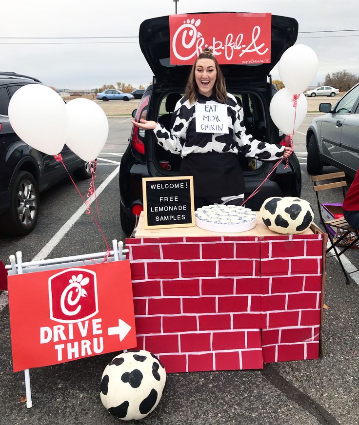 a woman sitting in the trunk of a car with balloons and signs on it that say drive thru