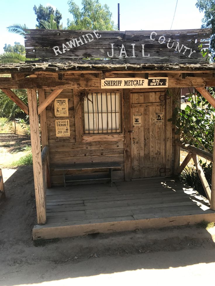 a small wooden building with a sign above it