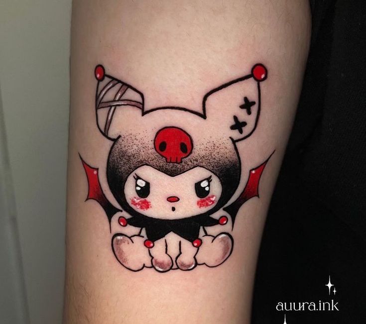 a small tattoo on the arm of a person with a red nose and black eyes