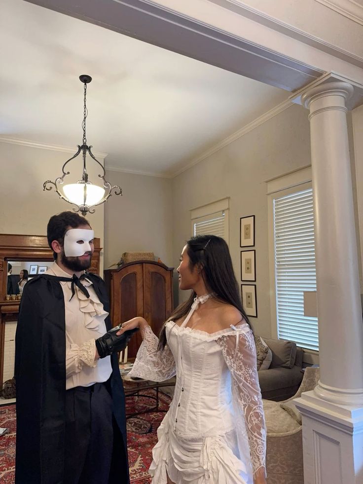 a man and woman dressed up in costume standing next to each other with makeup on their faces