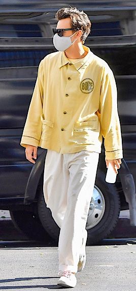 a man walking down the street wearing a face mask