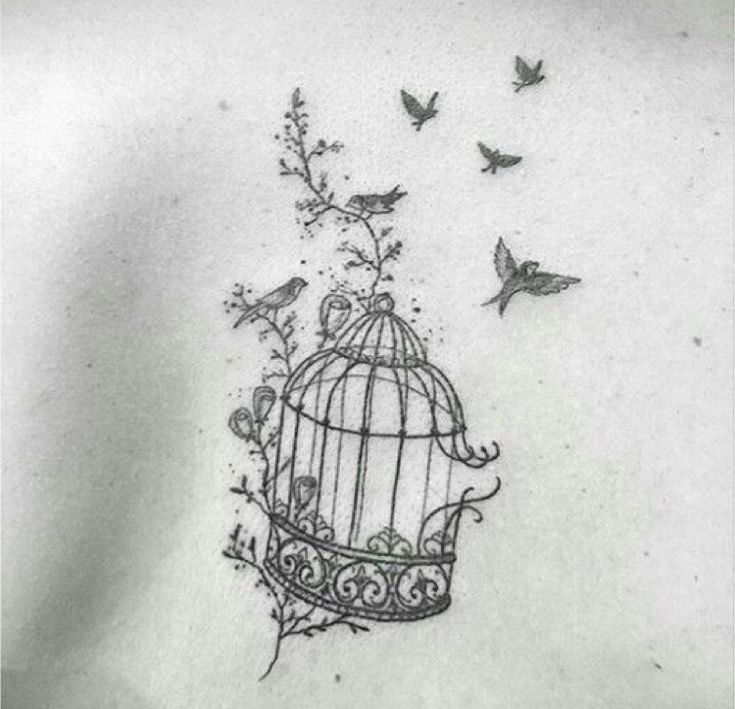 a birdcage with birds flying around it on the back of a woman's shoulder