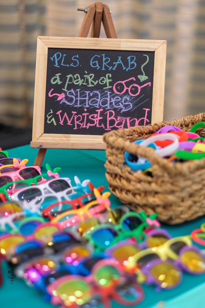 a table topped with lots of colorful sunglasses and a sign that says pis grab