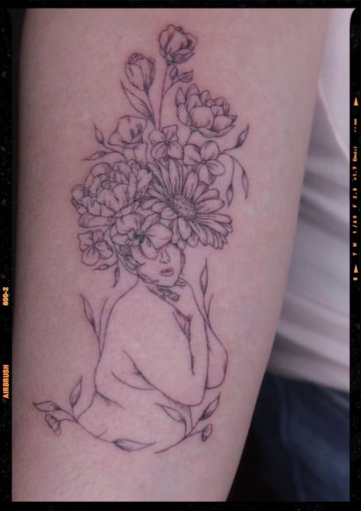 a woman's arm with flowers on it, and the outline of her body