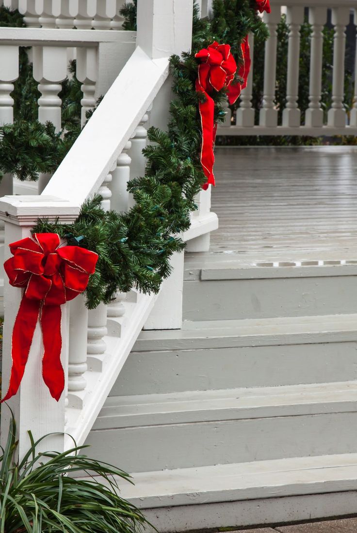 christmas garland tied to the banisters with red bows