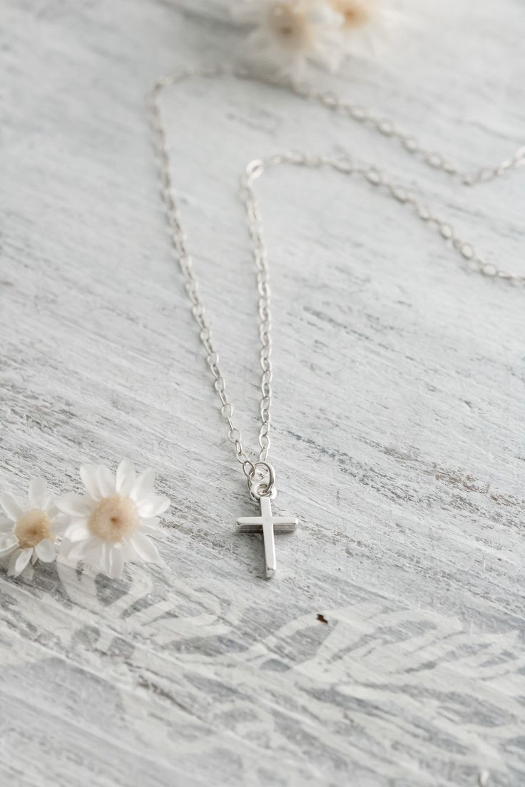 Display your faith with this handcrafted sterling silver dainty cross necklace. This beautiful simple necklace is lightweight and perfect for everyday wear. The cross is more than the universal symbol of Christianity. This simple design carries the message of love, finality, fulfilled promises, and more to people around the world. The perfect gift for baptism, first communion, confirmation and more. Make your necklace even more special with the addition of a birthstone or initial charm. ✥ Solid Simple Everyday Cross Pendant Necklace, Simple Sterling Silver Cross Pendant Necklace, Simple Everyday Cross Necklace, Delicate Sterling Silver Cross Pendant Necklace, Dainty Cross Necklace For Everyday, Minimalist Sterling Silver Cross Necklace, Silver Sterling Cross Necklace With Delicate Chain, Sterling Silver Cross Necklace With Delicate Chain, Everyday Sterling Silver Crucifix Necklace