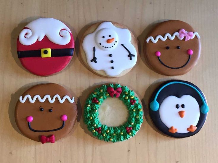 six decorated cookies sitting on top of a wooden table