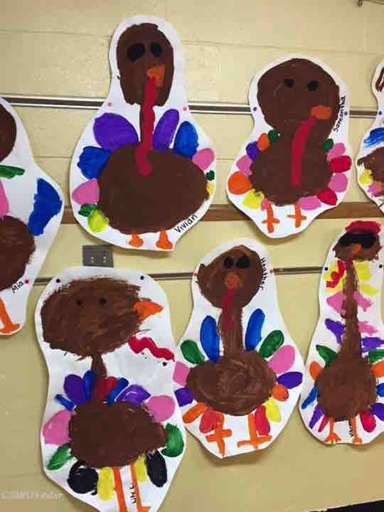 paper plates with turkeys on them are hanging from the wall in front of a bulletin board