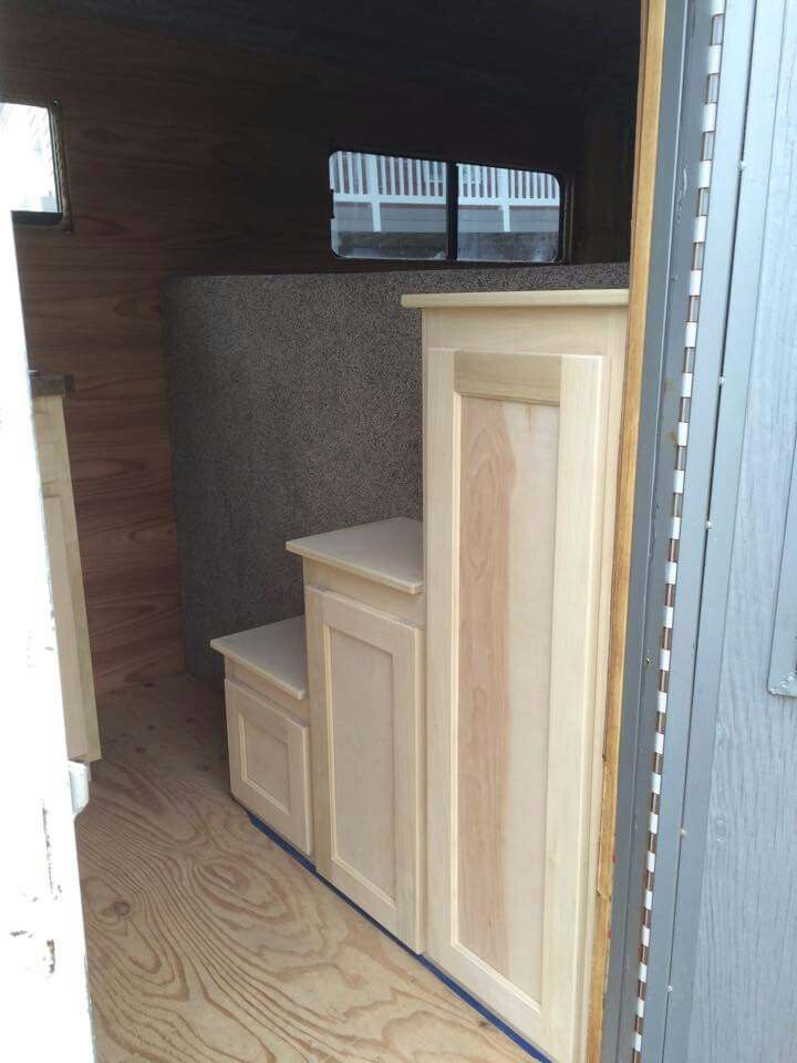 the inside of a horse trailer with its doors open and some drawers in place for storage