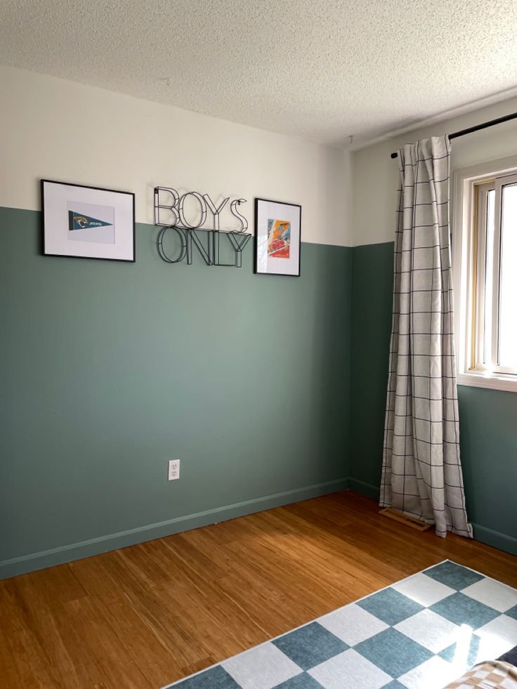 a living room with green walls and pictures hanging on the wall, along with a checkered rug