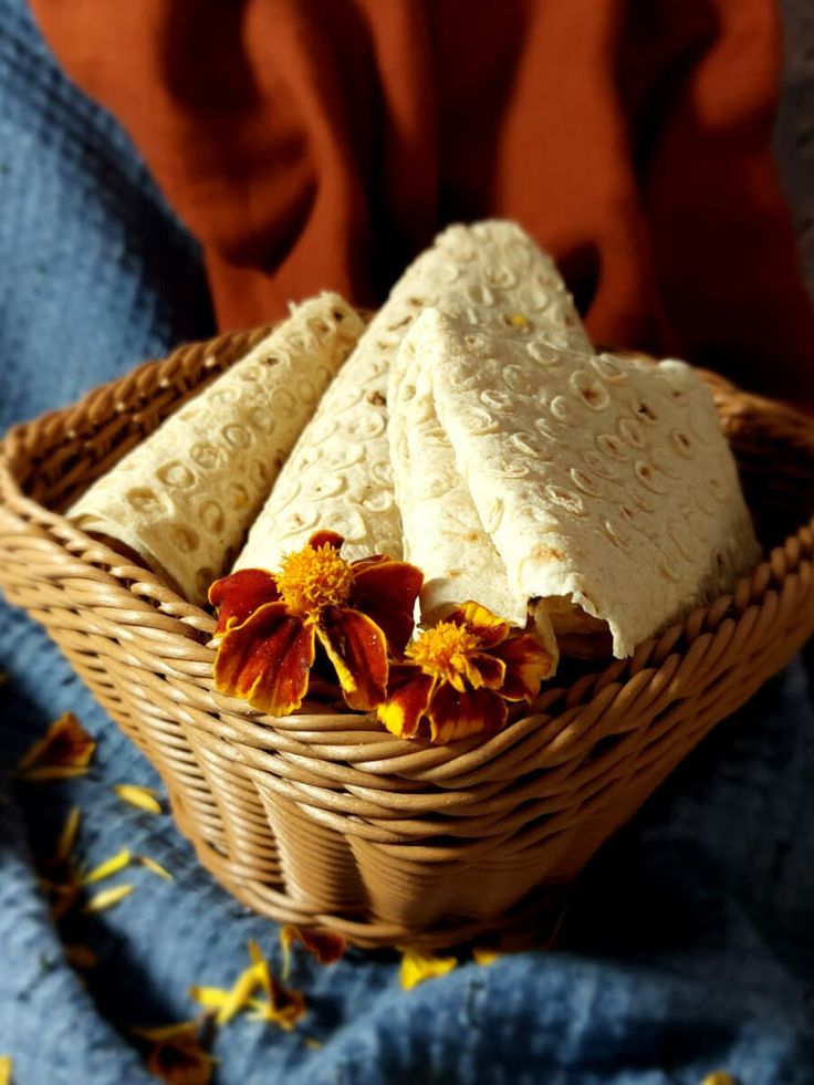 two pieces of bread in a basket with flowers