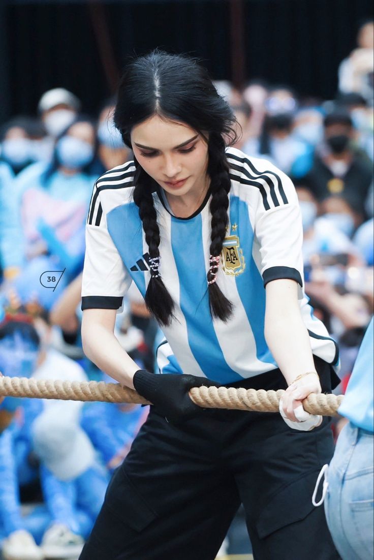 a woman with long hair pulling on a rope