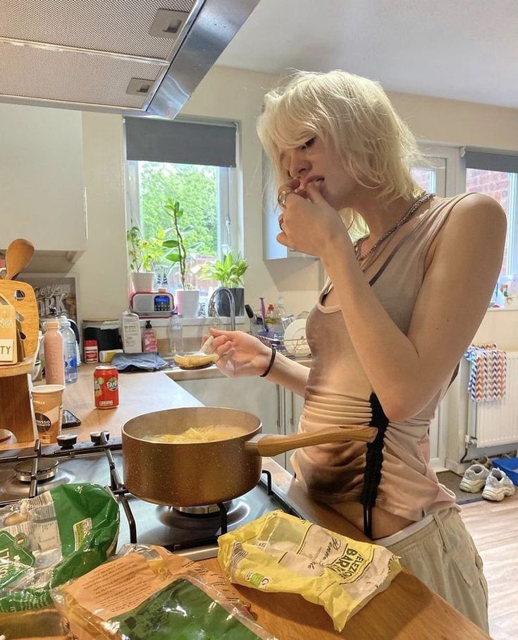 a woman standing in a kitchen making food