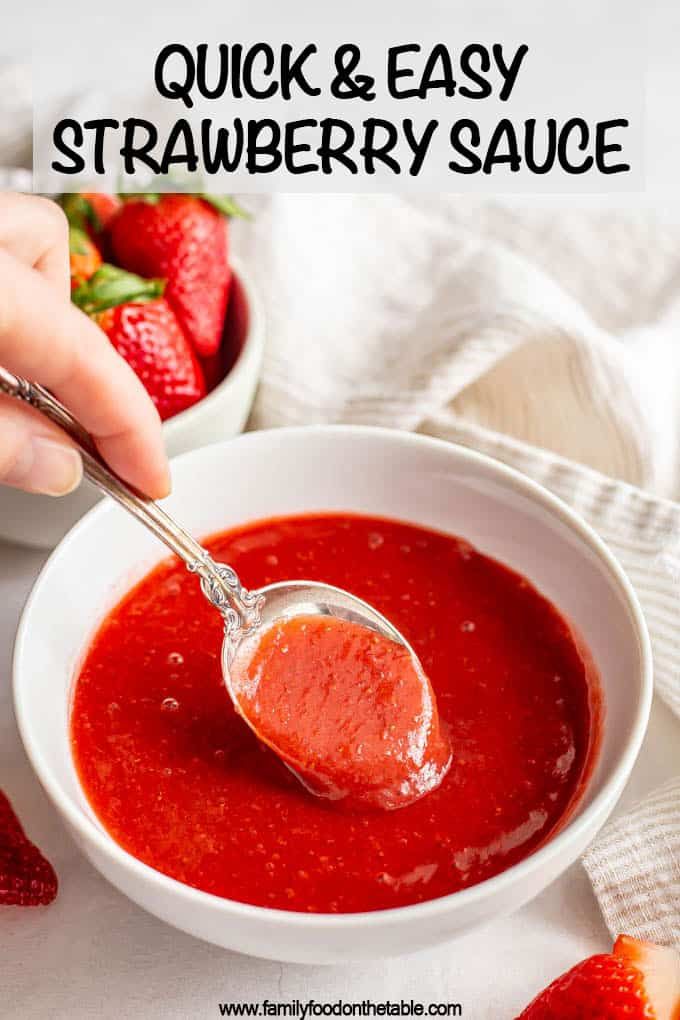 someone is dipping some strawberries into a bowl of tomato sauce with a spoon in it