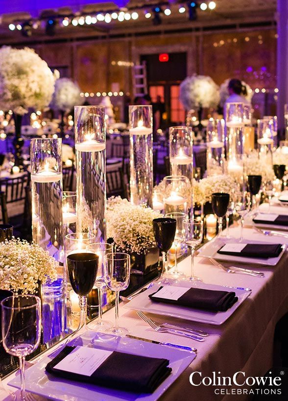 a long table is set up with wine glasses, candles and flower centerpieces