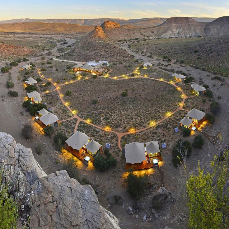 an aerial view of some huts in the middle of a field with lights on them