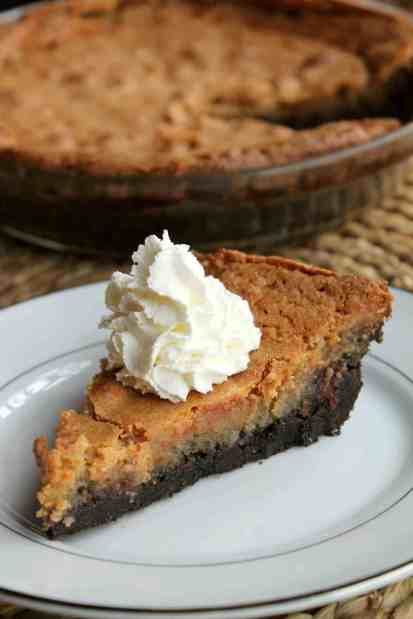 a slice of pie with whipped cream on top sits on a plate next to the pie