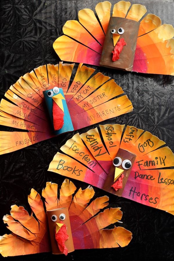 paper plate turkeys with words written on them, and two different colored feathers in the middle