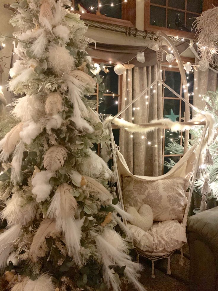 a decorated christmas tree in a living room next to a window with lights on it