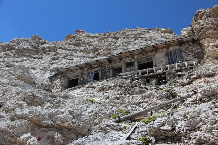 an old building built into the side of a rocky mountain with stairs leading up to it